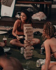 Two girls in swimsuits playing drunk jenga and learning the drunk jenga rules.