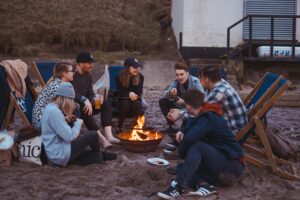 Campfire party where friends act out Mafia game rules with secret roles and group discussion